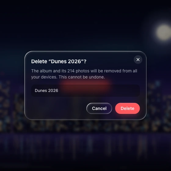 A frosted confirmation dialog over a dimmed, blurred night-city scene, with a filled confirm field, a glass Cancel and a solid red Delete.